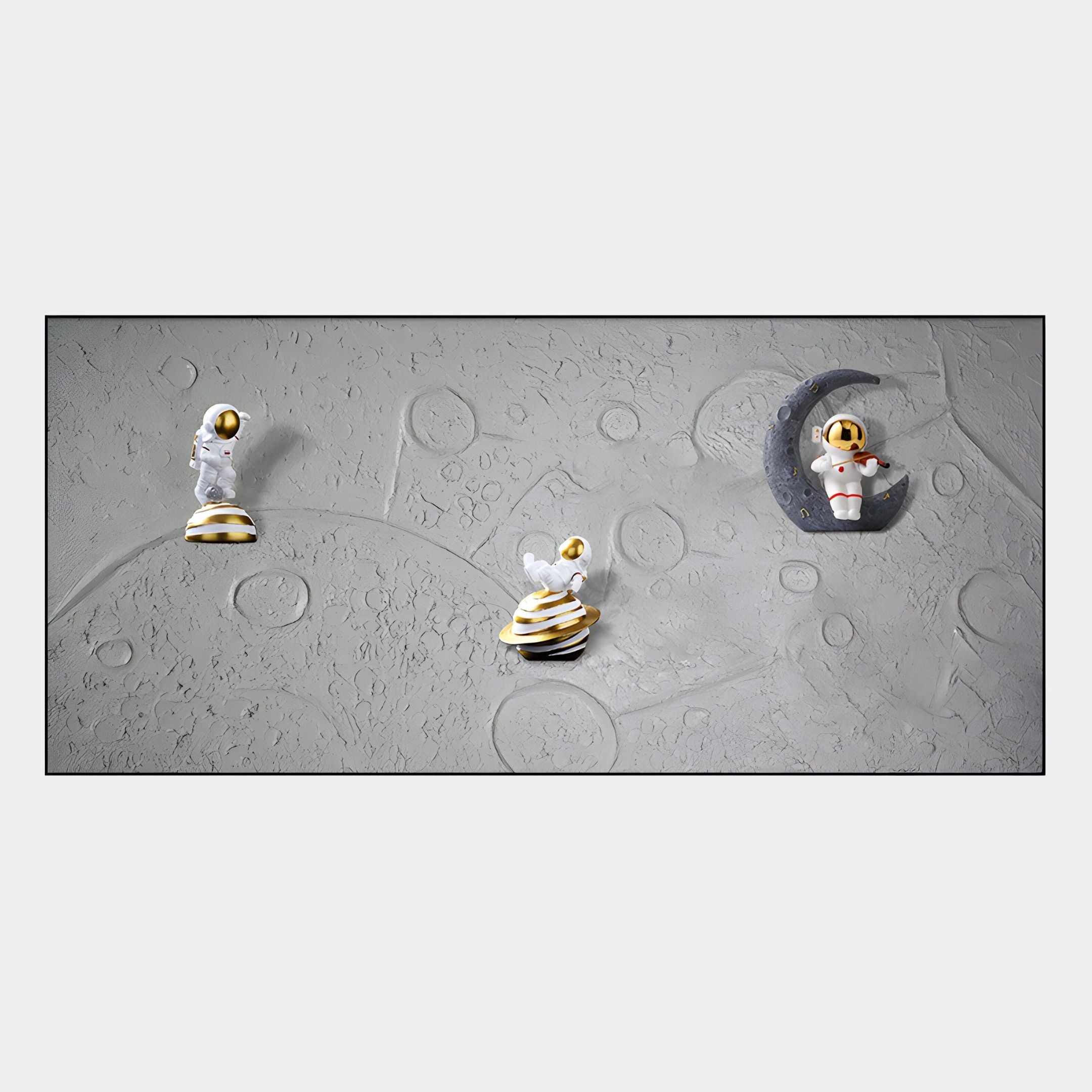 Three Astravera Moon Patrol Gold Accents Astronaut 3D Wall Art figurines by Giant Sculptures—one on a crescent moon, two nearby—sit on a cratered gray base, making them ideal children’s room decor or unique astronaut-themed wall art.