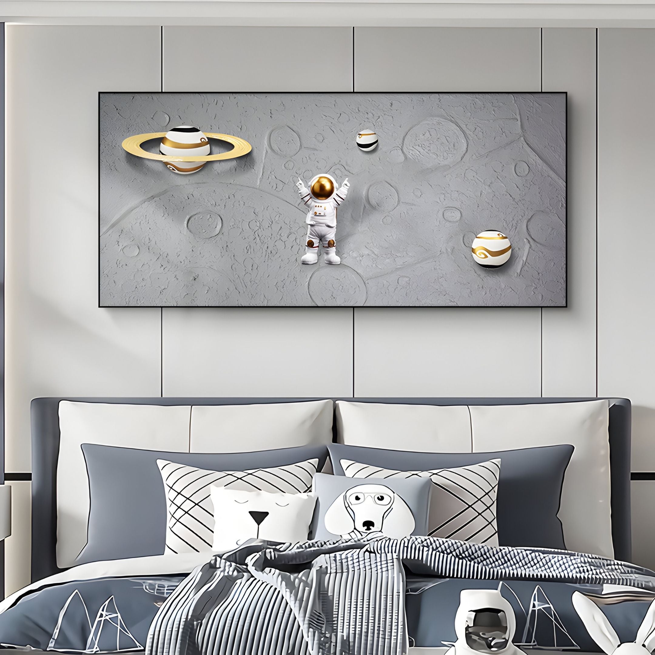 A modern bedroom features a bed with patterned pillows and Giant Sculptures’ Astravera Saturn Loop Gold Ring Planet Astronaut 3D Wall Art above it, showing an astronaut floating amid planets on a textured gray moonlike surface.
