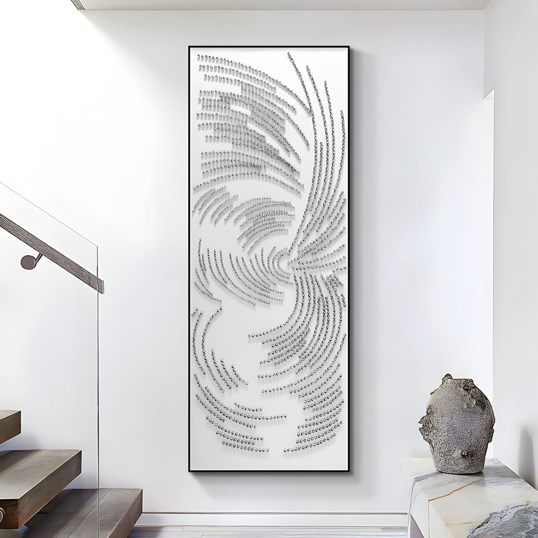 The Auravolta I Pearl Beads Swirl Pattern 3D Wall Art by Giant Sculptures, featuring textured metallic-gray swirls, hangs on a white wall beside a staircase and a decorative sculpted rock.