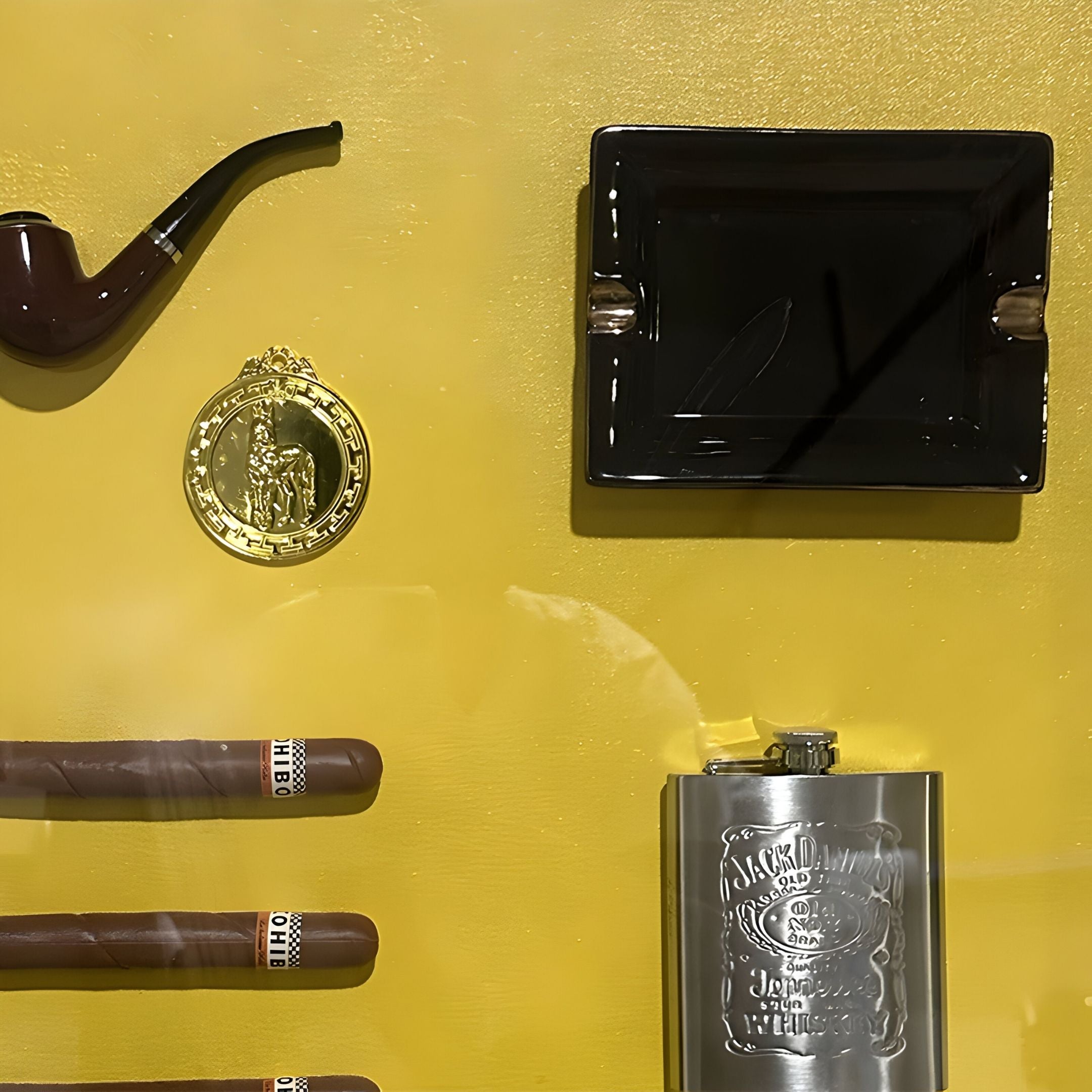 Featuring a smoking pipe, gold medallion, cigars, and more, the Gentaro Cigar & Gentleman Collectible Display Wall Art by Giant Sculptures adds vintage style to any smoking lounge or collector’s space.