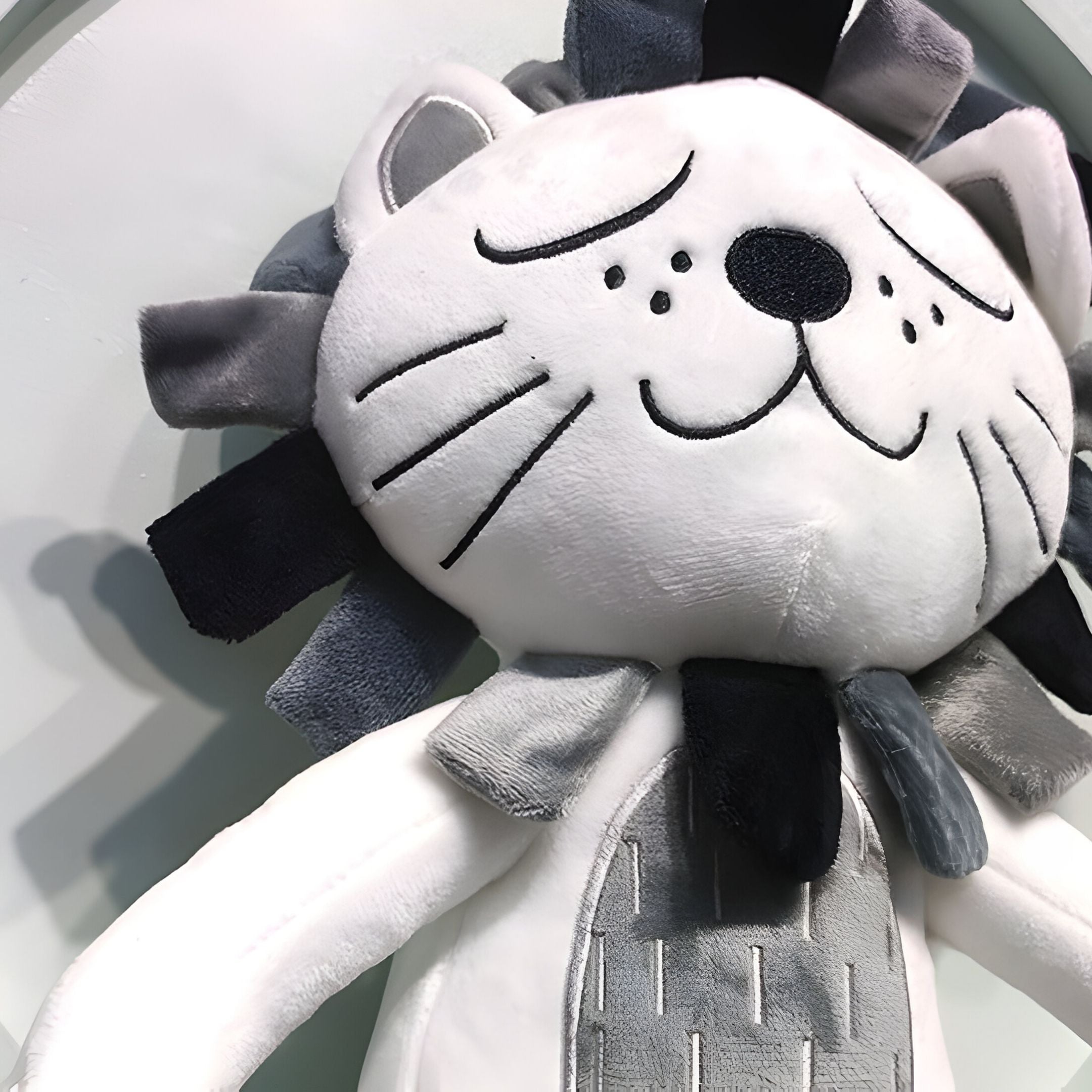 A close-up of the Cuddiloft Grey Lion Plush Display 3D Wall Art by Giant Sculptures, featuring a white face, closed eyes, stitched whiskers, and a gray and black mane—perfect for kids room decor.