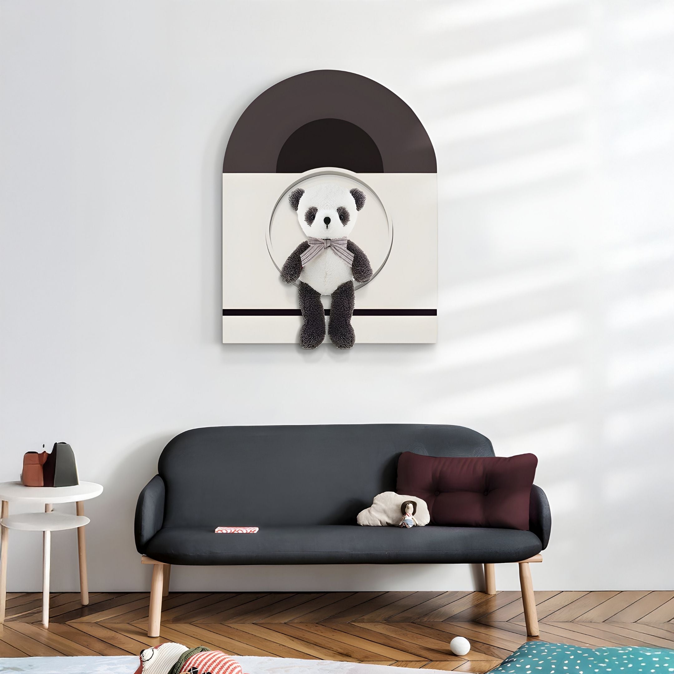 A modern living room features a dark gray sofa with a small pillow and stuffed toy. Above, the Cuddiloft Panda Plush Display 3D Wall Art by Giant Sculptures adds playful decor, while a turquoise rug and toys create a cozy atmosphere.