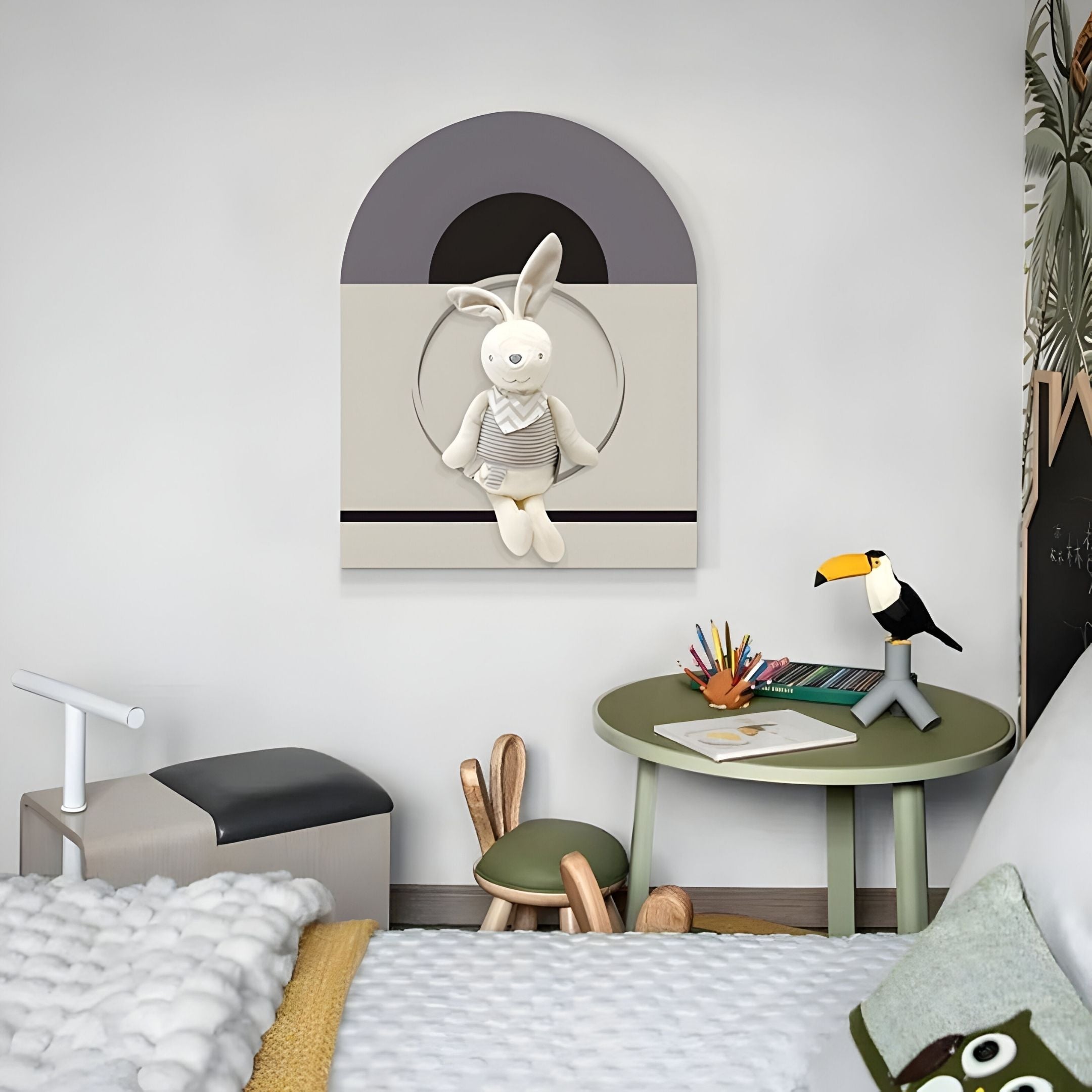 A children’s bedroom with a bed, green round table, colored pencils, toy toucan, bunny chair, and Giant Sculptures Cuddiloft Cream Bunny Plush Display 3D Wall Art—playful 3D nursery decor that adds a modern touch.