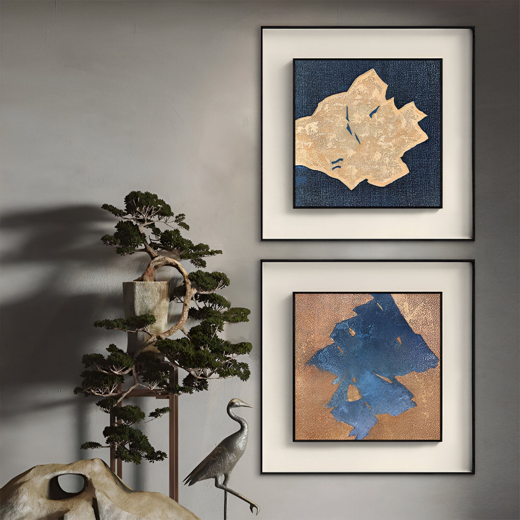 The Aeroluxe Sandform Blue Textured Abstract Framed Wall Art by Giant Sculptures, in gold, blue, and beige tones, hangs above a bonsai tree and metal crane sculpture, bringing a modern touch to your space.