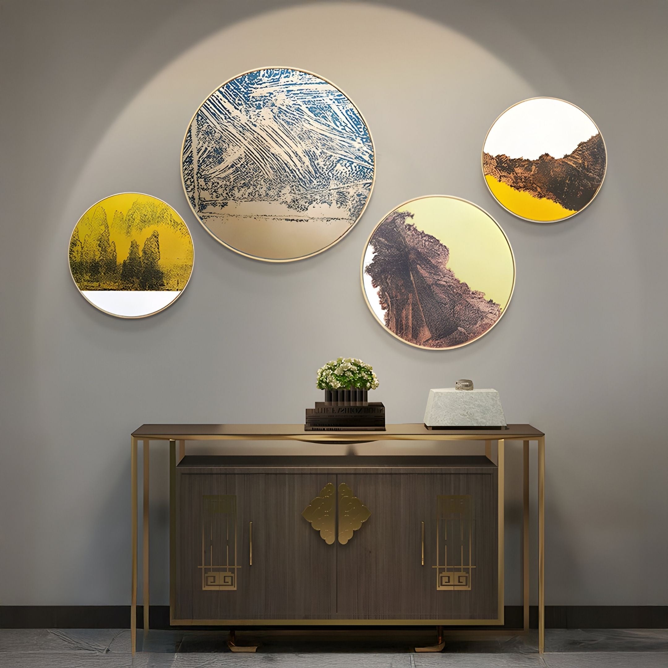 A modern console table with gold accents stands against a gray wall, topped with a potted plant and decorative box. Above it, Giant Sculptures’ Auralune Verdant Rise Textured Abstract Round 3D Wall Art creates a striking contemporary cluster.