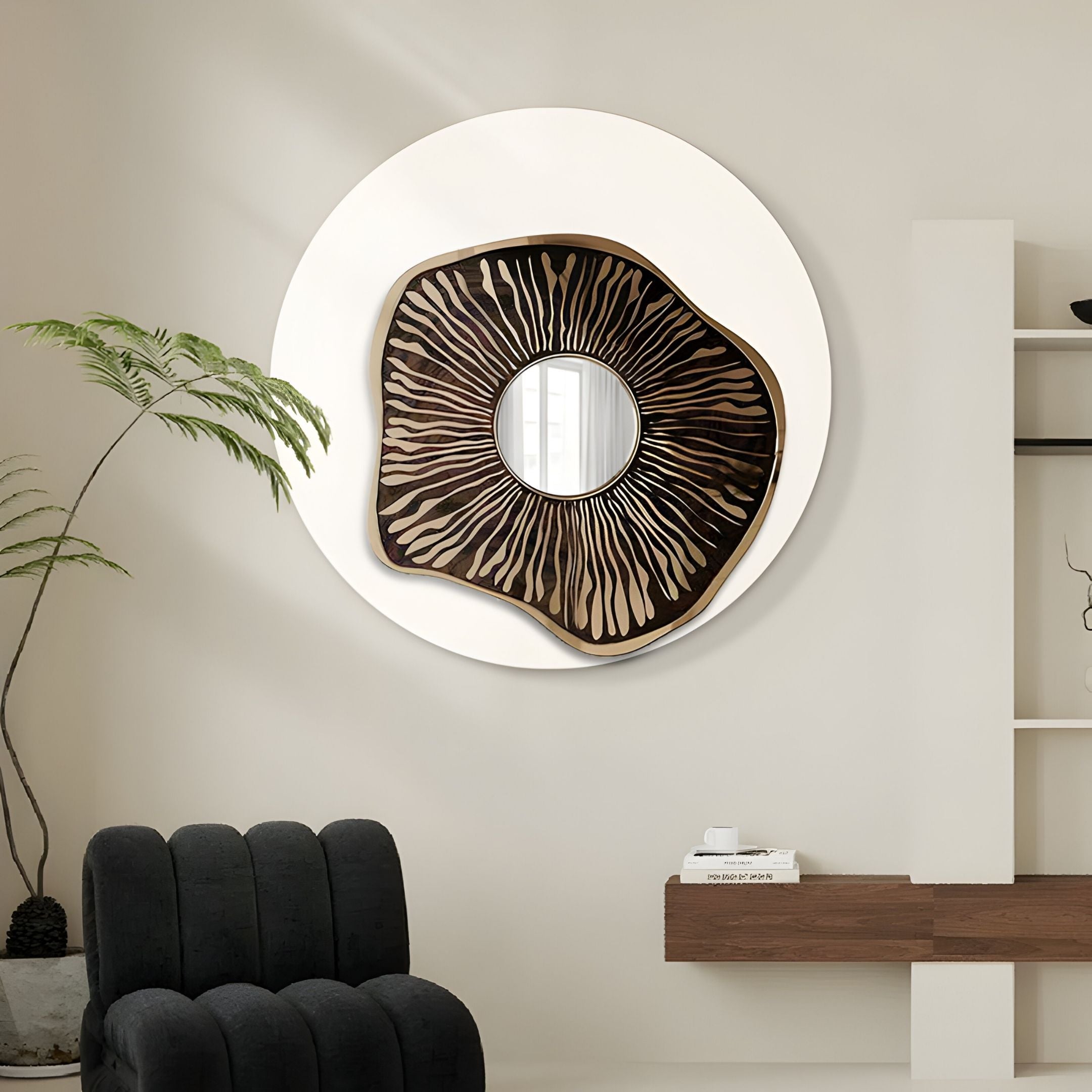 A modern living room showcases the Lunestre Bronze Ripple Organic Round Mirror 3D Wall Art by Giant Sculptures on a white wall, paired with a black chair, wooden floating shelf, and a tall green plant.