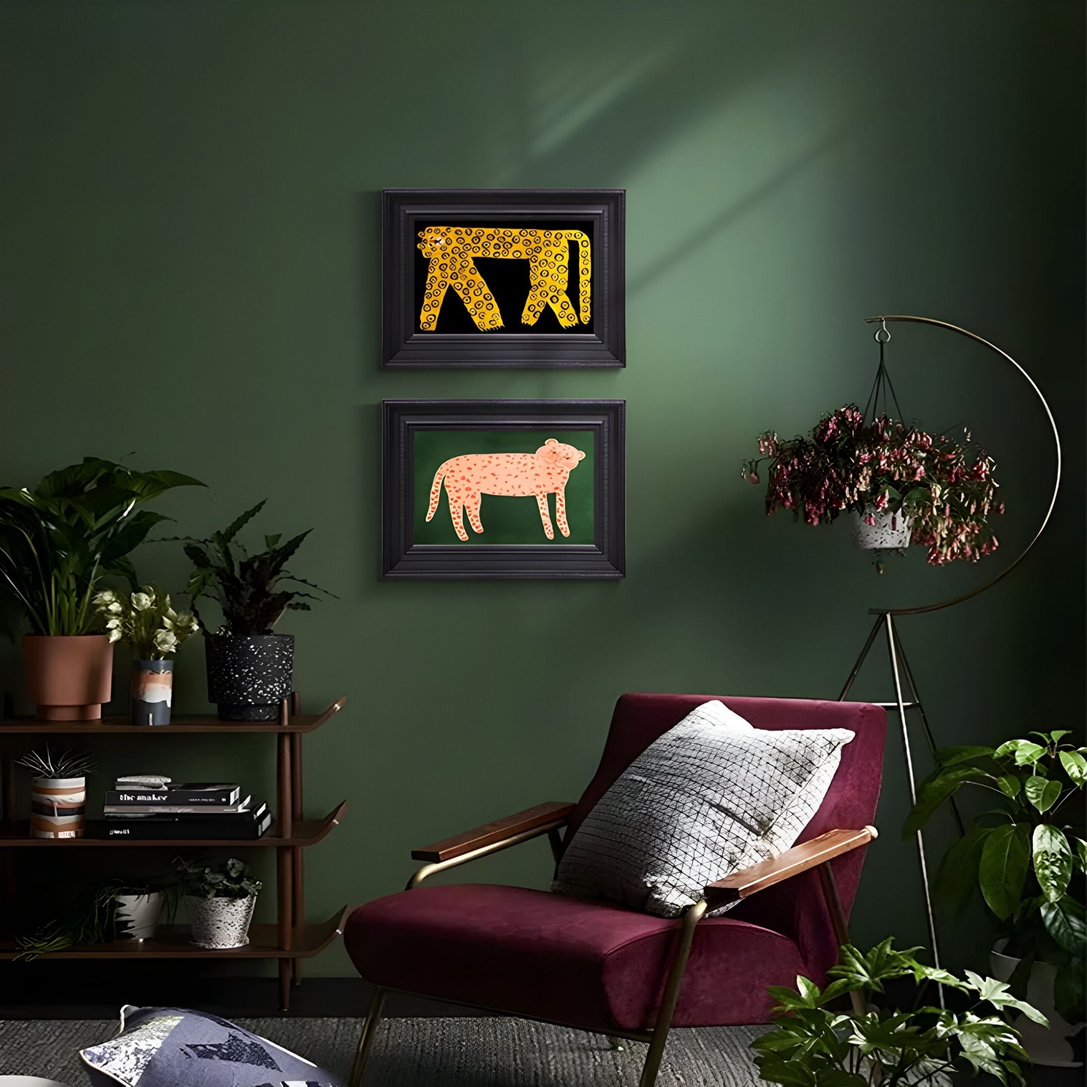 A cozy room with dark green walls, a burgundy armchair, potted plants, and the Ardensir Golden Leopard Duo 2-Set Framed Wall Art by Giant Sculptures—striking HD pieces featuring yellow cheetah and pink leopard above.