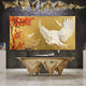 A luxurious room showcases Giant Sculptures’ Aurellion White Birds & Red Blossom Gold Panel 3D Button Wall Art, featuring two white birds among red blossoms on a dark textured wall beneath ornate golden ceiling decor.