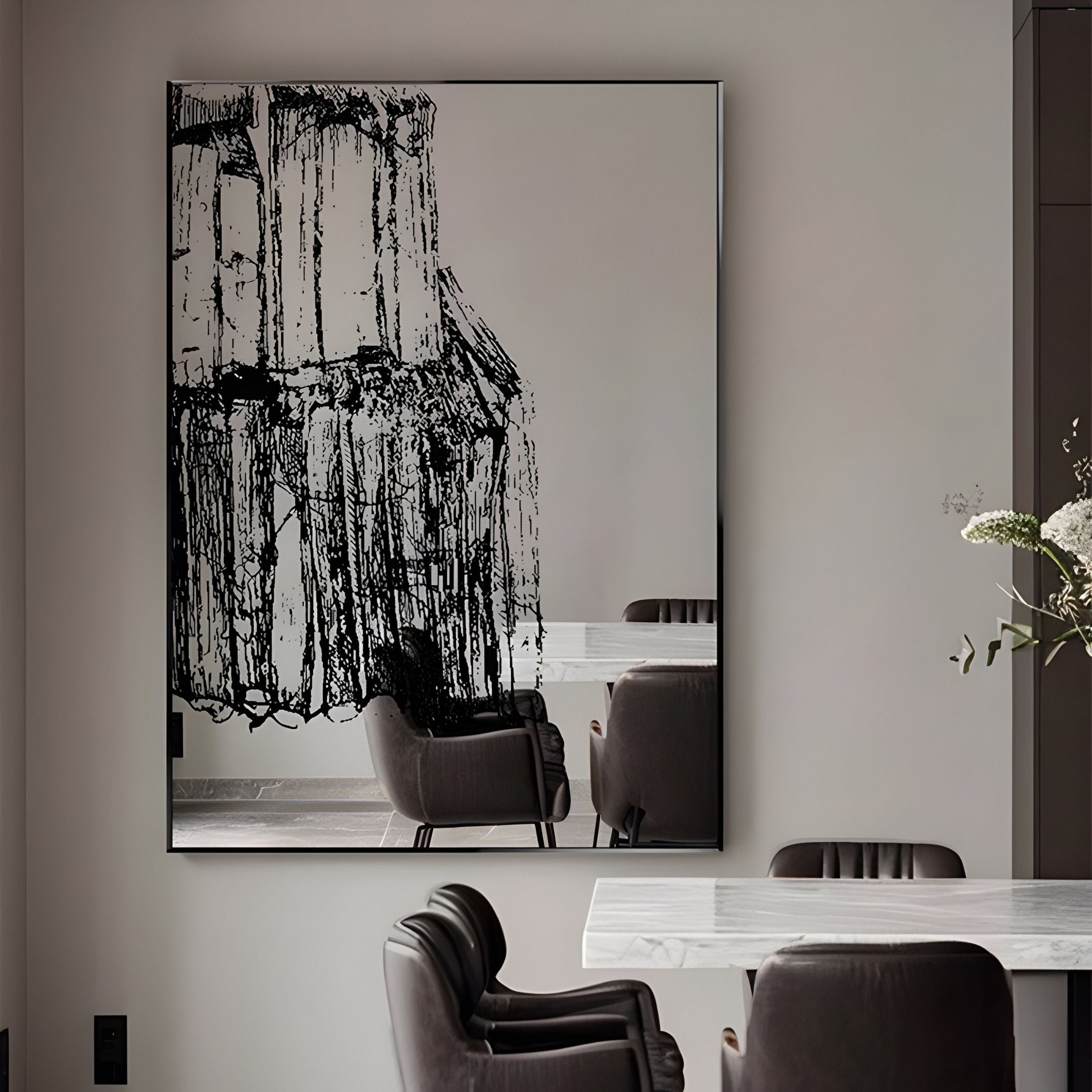A modern dining room with a white marble table, gray cushioned chairs, and the Rivarenne Black Abstract Texture Steel Mirror 3D Wall Art by Giant Sculptures. A vase with white flowers on the table adds an elegant touch.