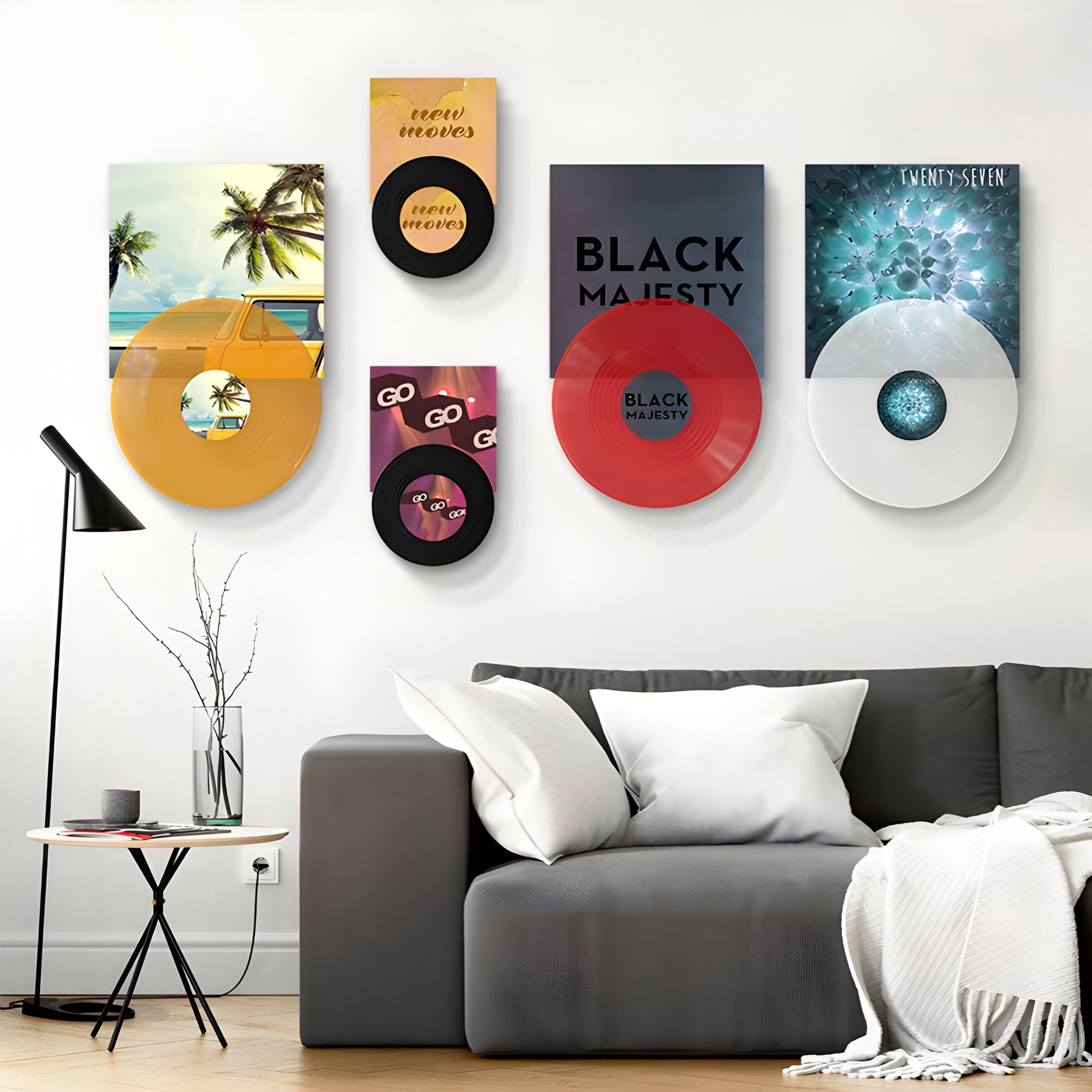 The Vinylscape Colour Pop Records 5-Panel Wall Art by Giant Sculptures adds a vibrant, music-inspired accent above a gray sofa with white pillows and blanket, next to a minimalist floor vase—ideal for modern interior art lovers.