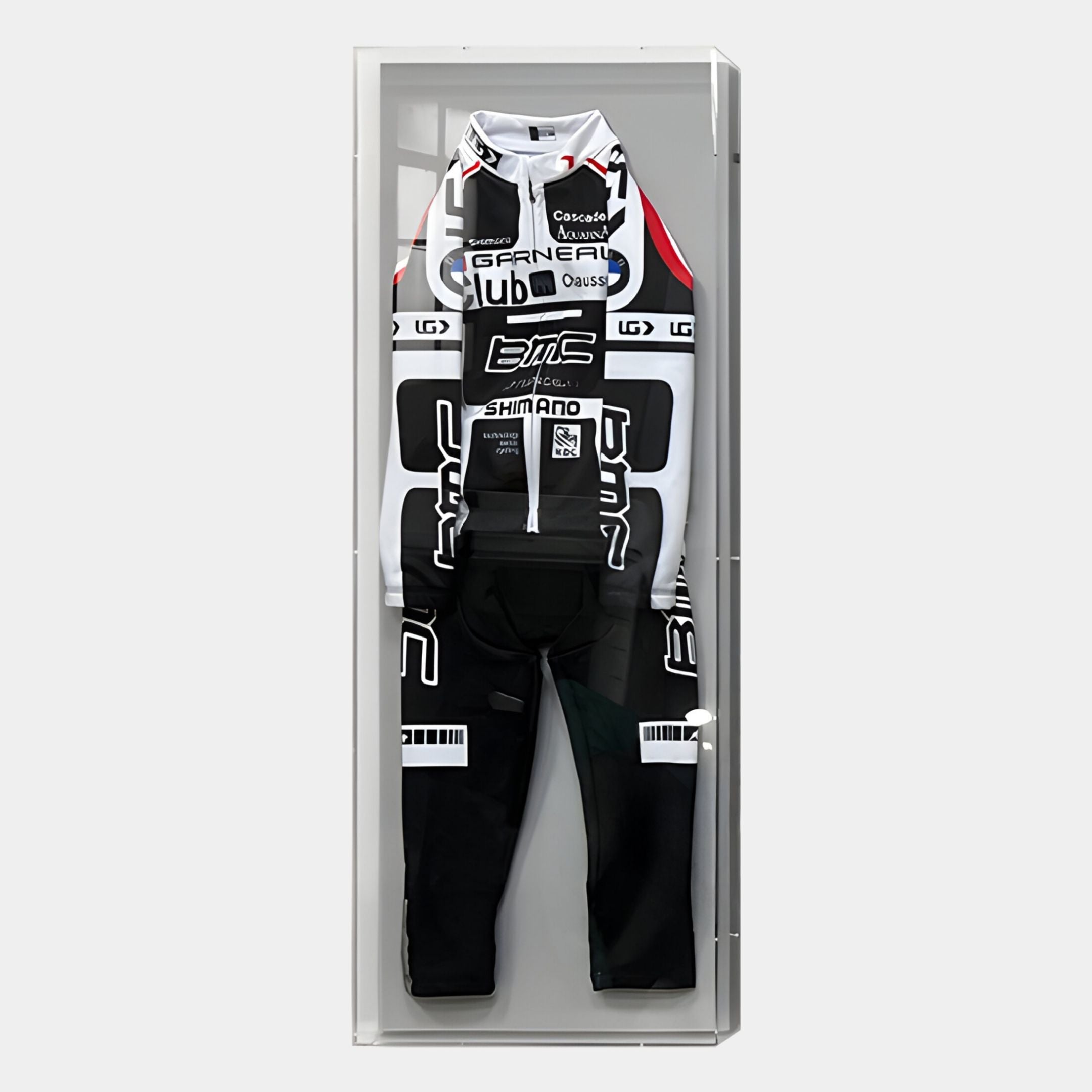 The Apexline Motorsport Racing Suit Acrylic Box 3D Wall Art by Giant Sculptures features a black and white cycling suit with sponsor logos, bold geometric patterns, and branding, displayed in a glass case against a light background.