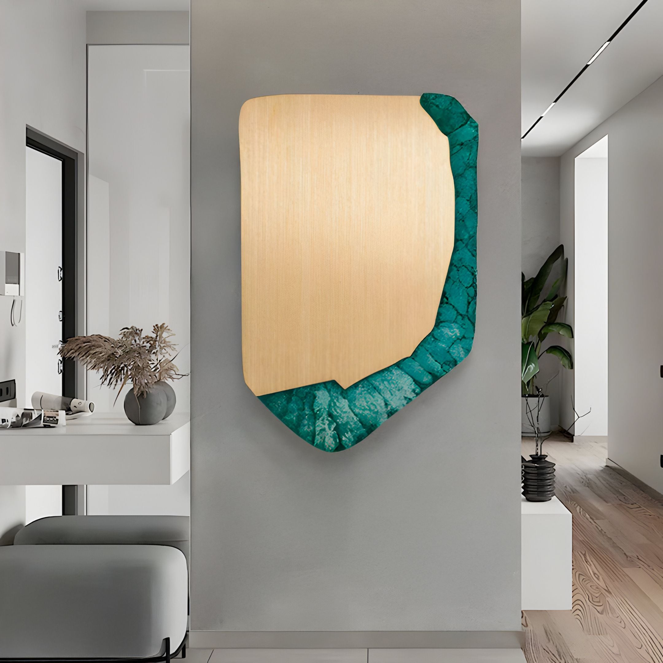 A modern hallway showcases the Gildrift Gold Steel & Emerald Stone Edge Textured 3D Wall Art by Giant Sculptures above a white console table decorated with dried plants and minimalist accents.