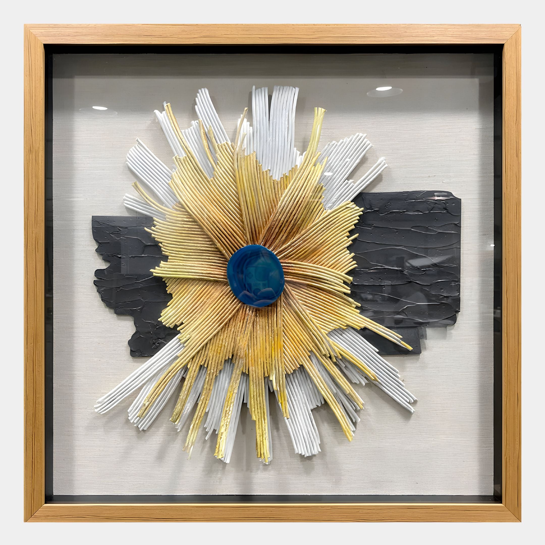 The Asterfold II White & Yellow Sunburst 3D Wall Art by Giant Sculptures features gold and white rays radiating from a blue center, set on a black background—ideal as striking modern decor for any interior.