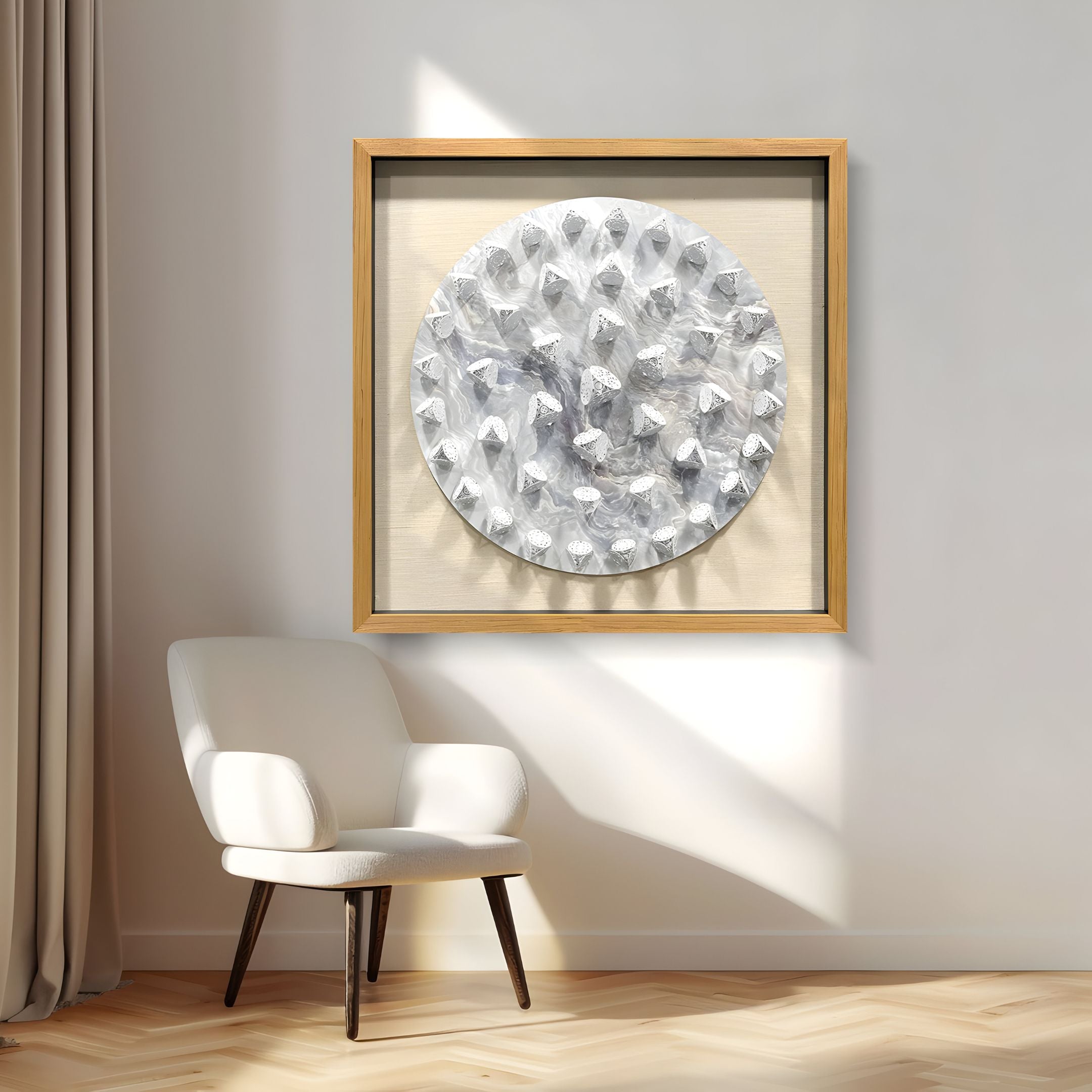 A modern armchair with wooden legs sits by beige curtains. Above it hangs Steelune Silver Metal Disc Spike 3D Wall Art by Giant Sculptures, featuring raised geometric patterns on a light wall bathed in natural light.