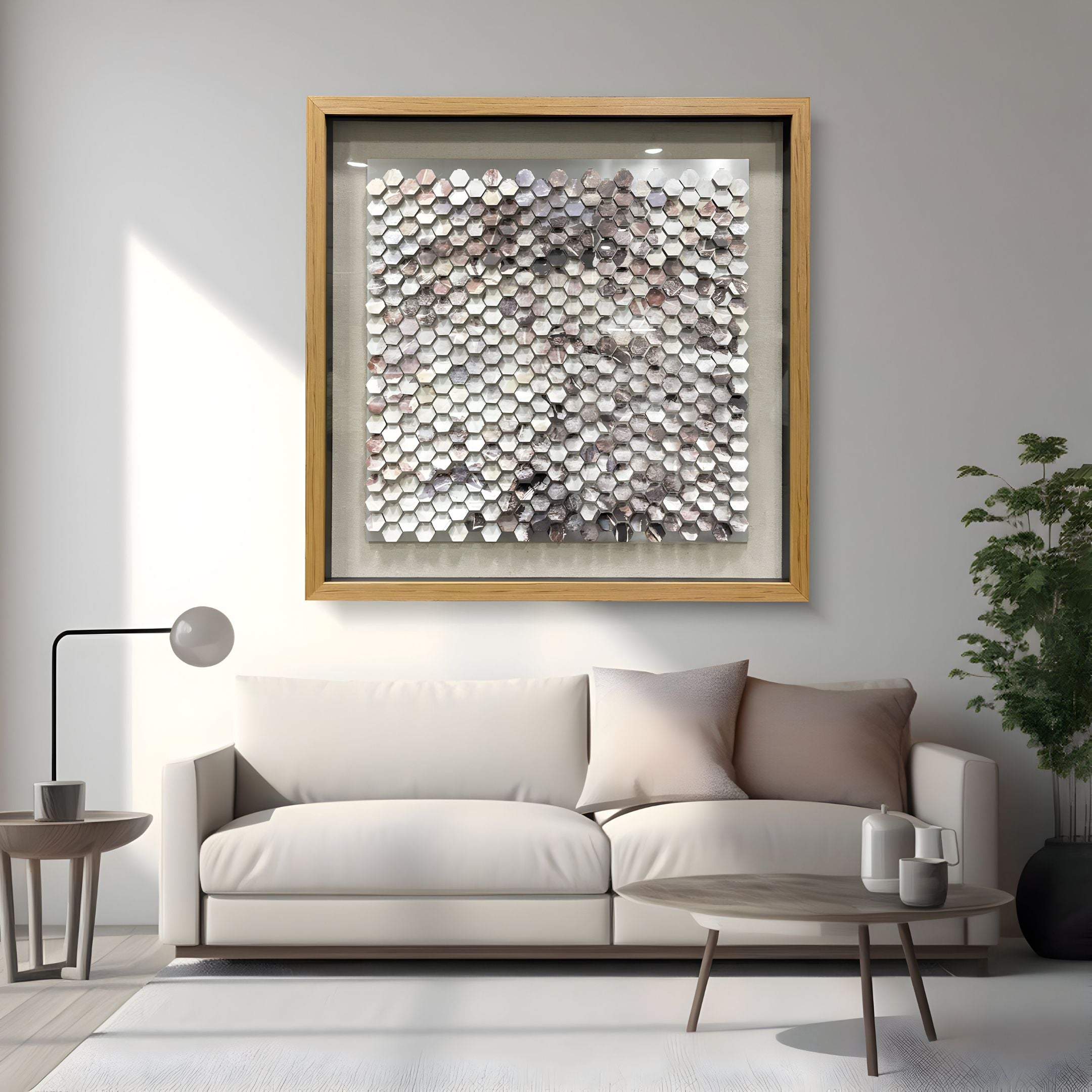 A modern living room with a beige sofa and neutral decor features the Tessora White & Smoke Hex Mosaic Metal 3D Wall Art by Giant Sculptures above the sofa—making a chic statement with its striking metallic hexagons.