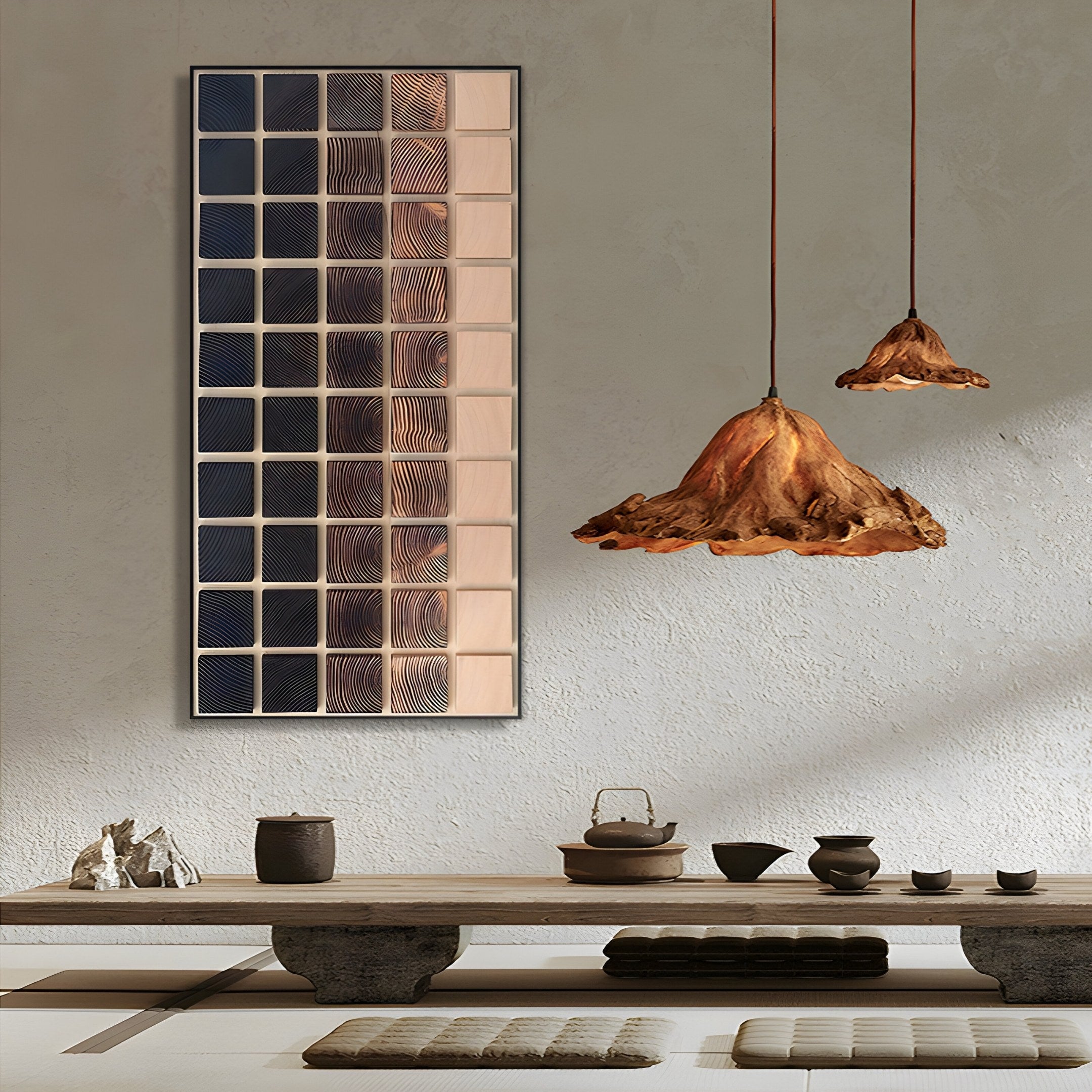 Minimalist tea room with a low wooden table set for tea, floor cushions, earthy ceramic teaware, two pendant lamps with organic brown shades, and Quadrelle Midnight & Sand Grid Geometric 3D Wall Art by Giant Sculptures.
