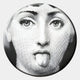 The Lunoria Playful Tongue Face Round Wood Embossed Wall Art by Giant Sculptures features a black and white woman's face with large eyes and a playful expression—ideal modern decor for any interior.