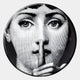 The Lunoria Silent Gesture Face Round Wood Embossed Wall Art by Giant Sculptures features a black and white woman's face with wide eyes and a shh gesture—an ideal modern portrait for striking wall decor.