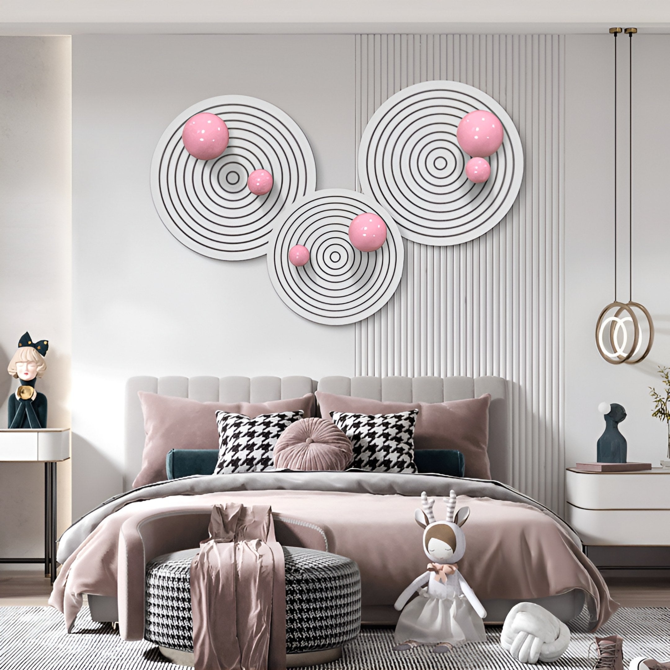 A modern bedroom in pink and gray features Giant Sculptures' Orbiora Pink Orb 3-Panel Concentric Sphere 3D Wall Art above the bed, complemented by decorative pillows, a plush toy, and stylish furniture.