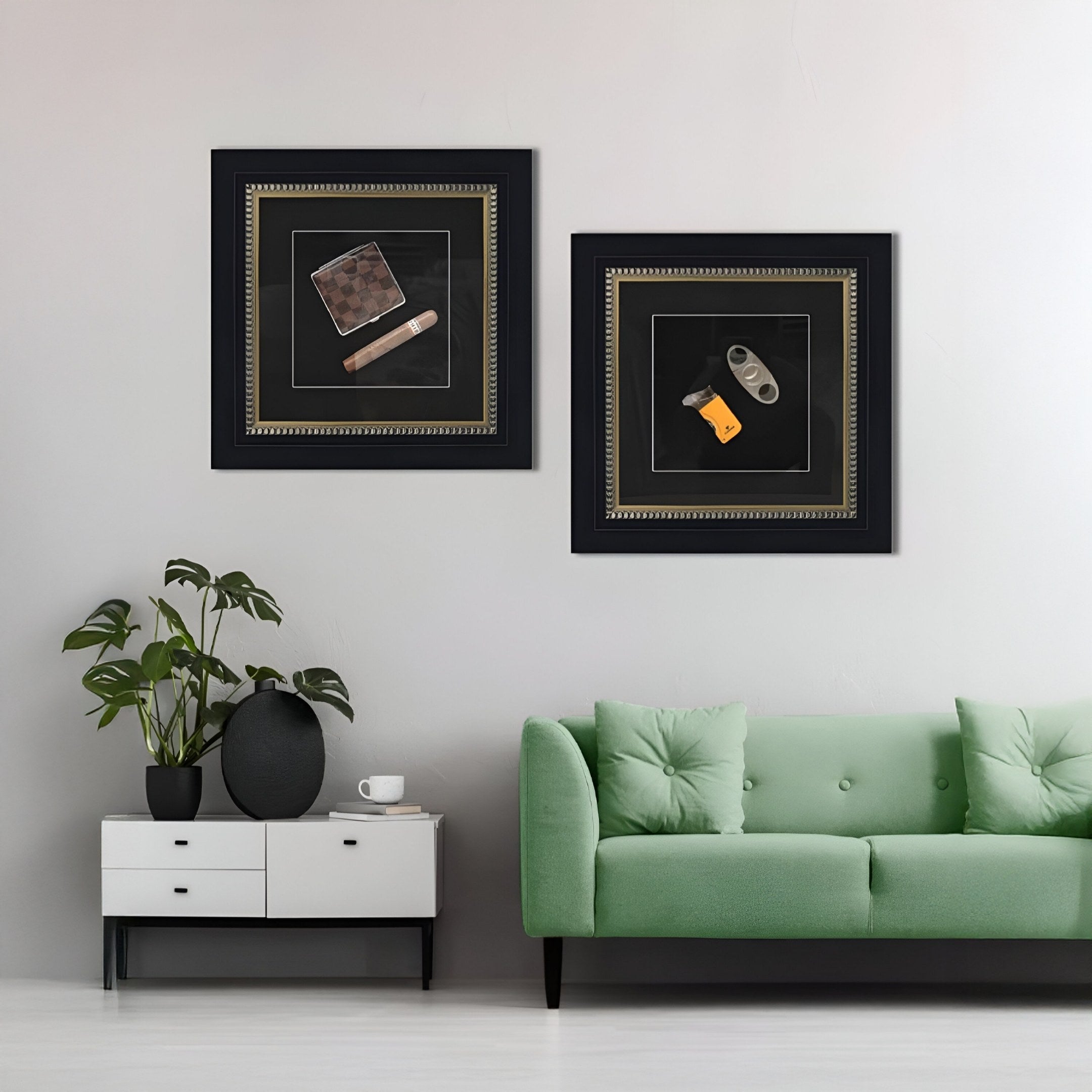 A modern living room features a light green sofa, a white side cabinet with plants and decor, and two Giant Sculptures Havantra Cutter & Torch Cigar Accessory Framed Wall Art pieces displayed above.