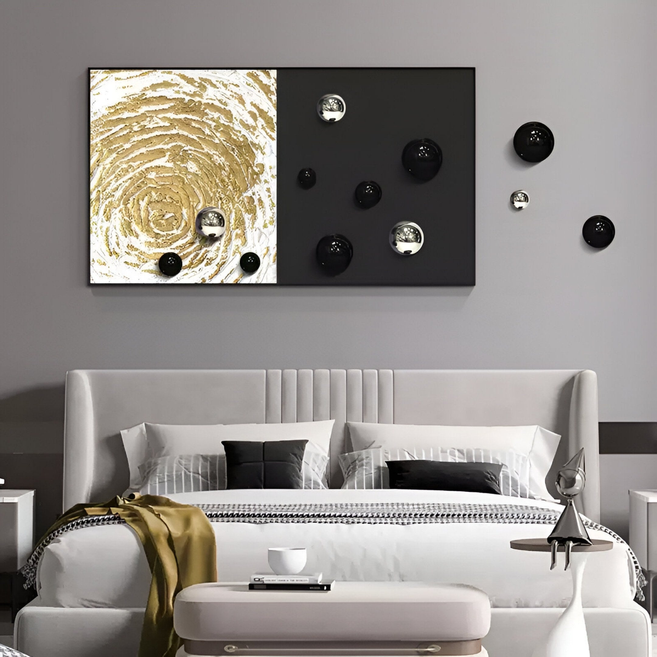 A modern bedroom with a gray bed, geometric cushions, a yellow throw, and Giant Sculptures' Spherium Black & Silver Orb Dual-Tone Panel 3D Wall Art above the headboard—gold swirls on one side, black with reflective spheres on the other.