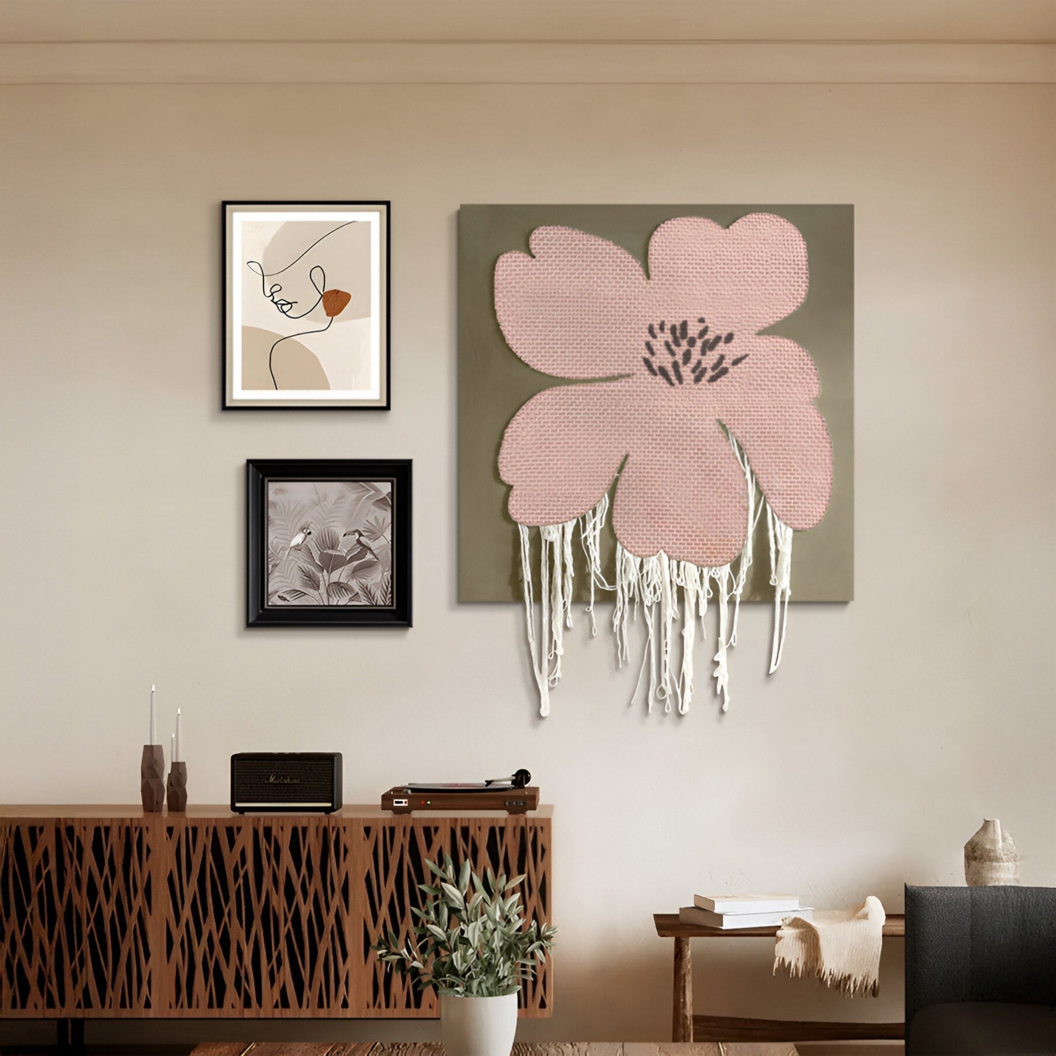 A modern living room features a wooden sideboard, a potted plant, and Giant Sculptures' Florayne 3-Set Blush Pink Woven Textured 3D Wall Art.