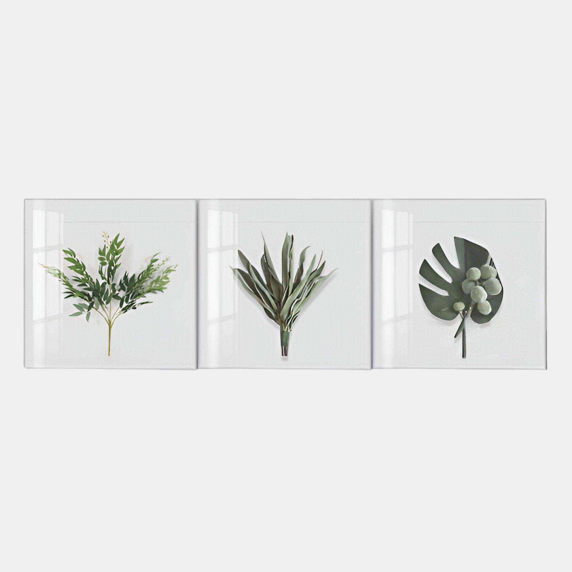 The Florvara Botanical Leaves 3-Panel Clear Acrylic 3D Wall Art by Giant Sculptures features unique green foliage designs on white, creating striking modern décor for any minimalist space.