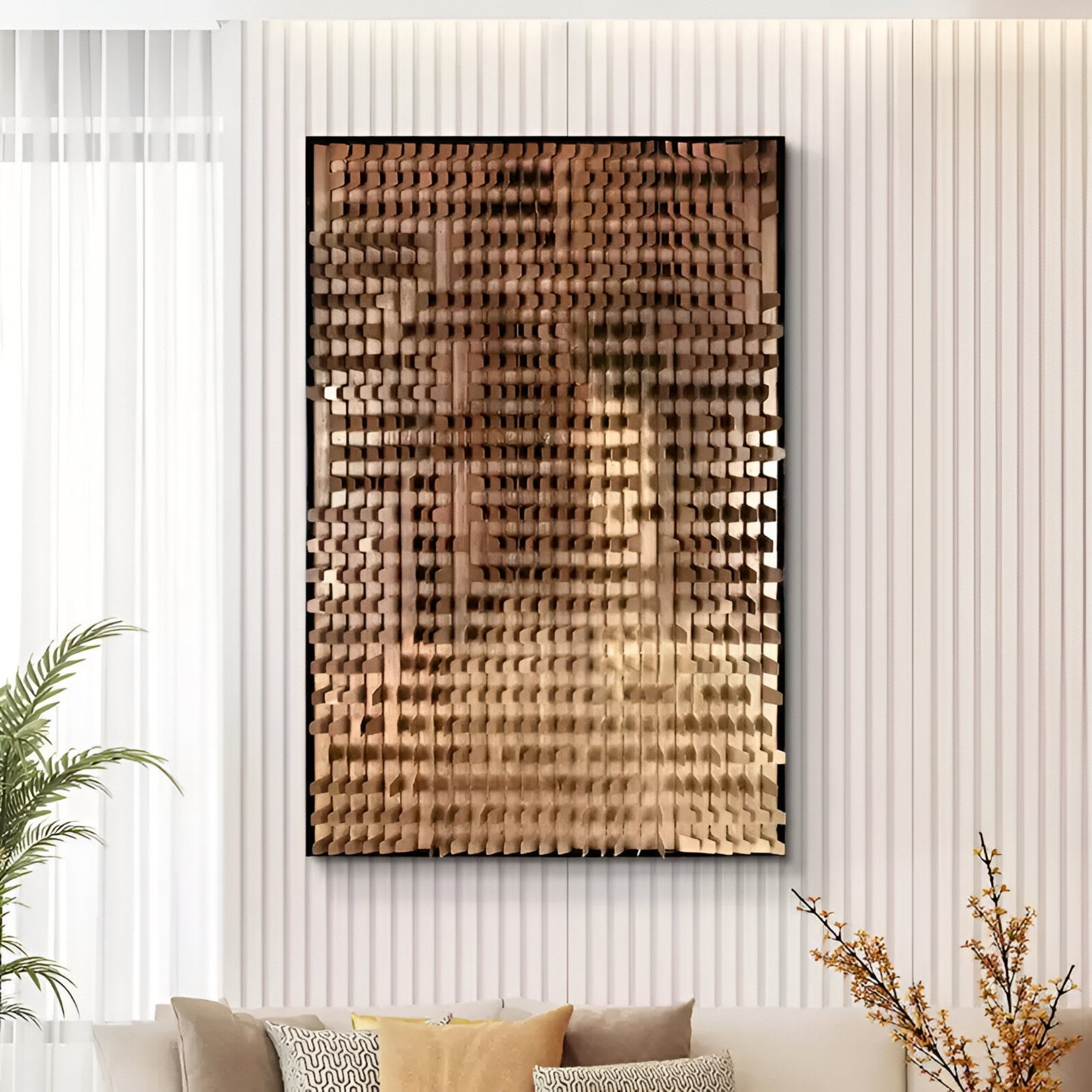 A modern living room with a white textured wall features the Gradalis Bronze Sculptural Metal 3D Wall Art by Giant Sculptures, showcasing reflective golden blocks in a grid above a beige sofa with patterned cushions.