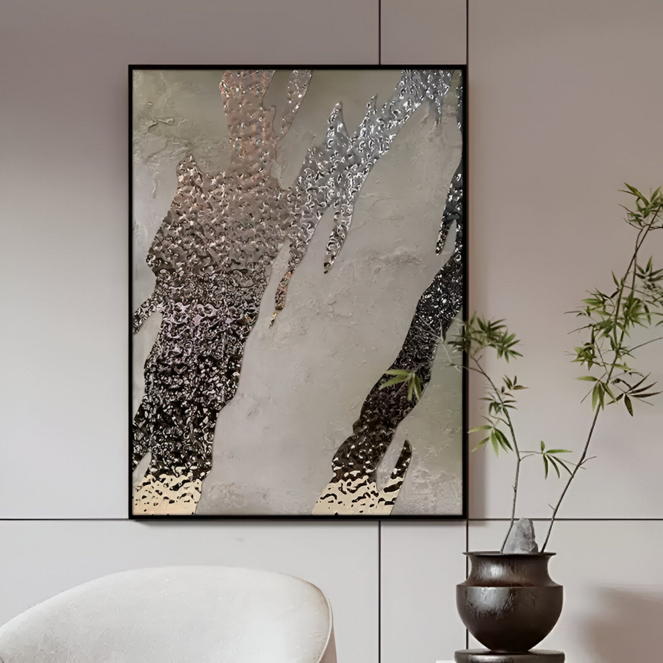 The Metallura Taupe & Silver Metallic Flow Abstract 3D Wall Art by Giant Sculptures features textured, wavy silver and gray patterns above a white chair, adding sculptural depth and modern style to your space. Complementary greenery enhances the decor.