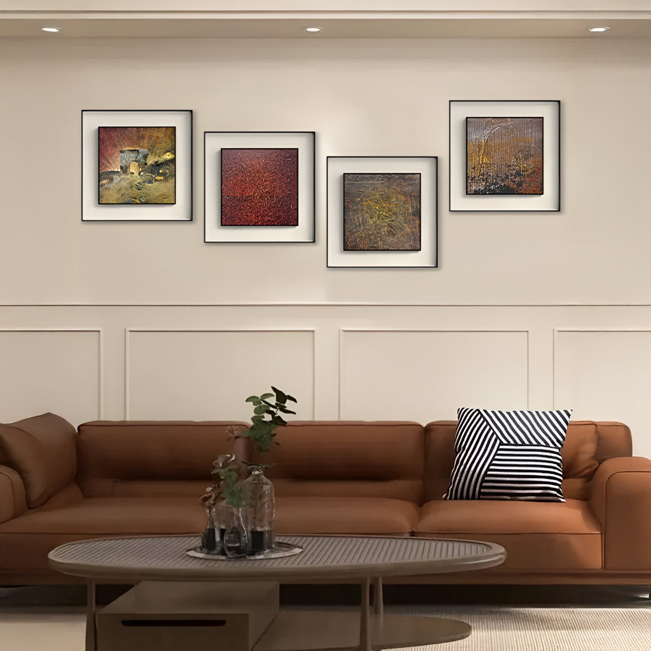A modern living room featuring a brown leather sofa, a striped black-and-white pillow, a round coffee table with vases, and four Fiorenze Golden Arch Pattern Textured Square 3D Wall Art pieces by Giant Sculptures above the sofa.