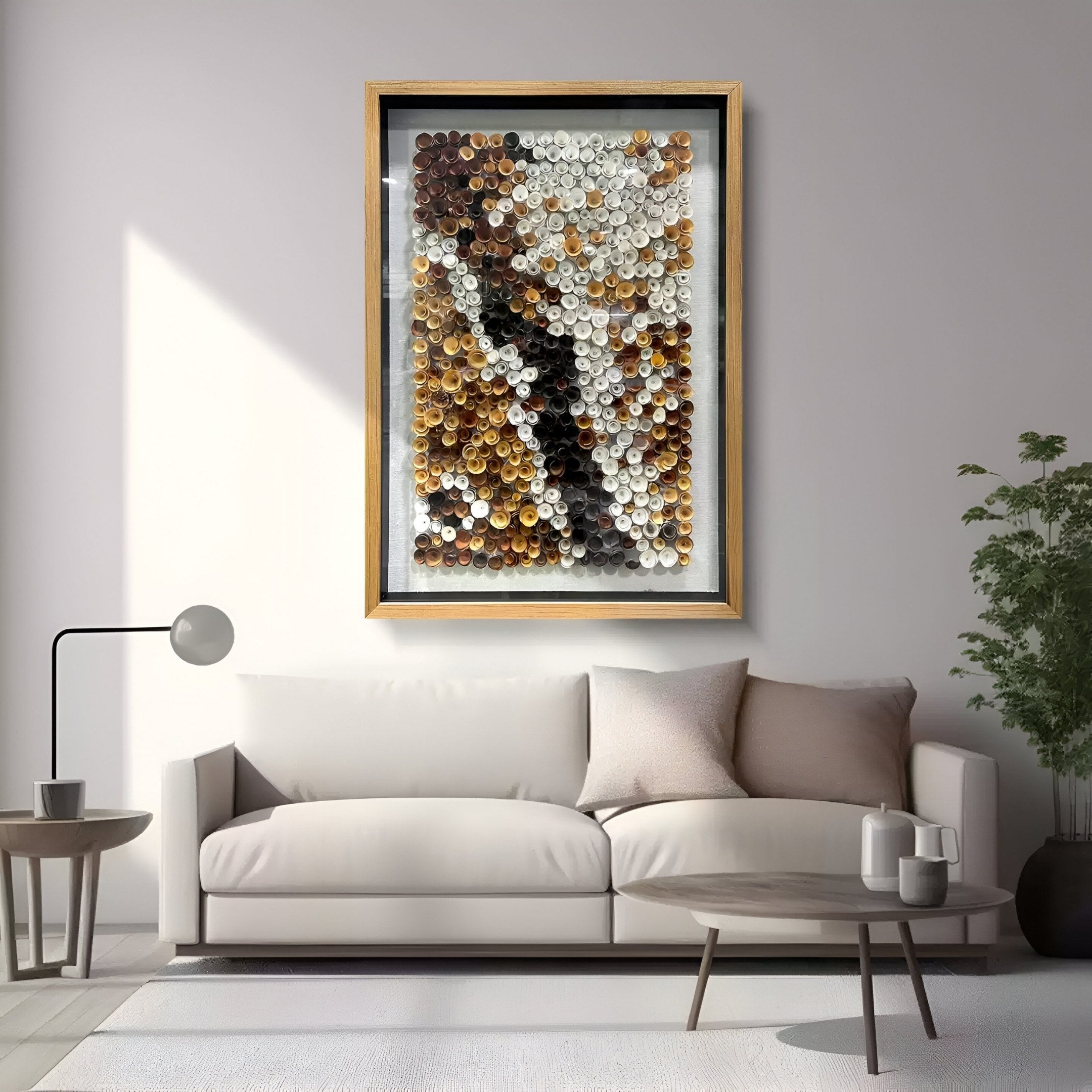 A modern living room features a light beige sofa, round coffee table, floor lamp, potted plant, and the Giant Sculptures Volaris Ochre & Ivory Rolled Floral Framed 3D Wall Art displayed above the sofa.