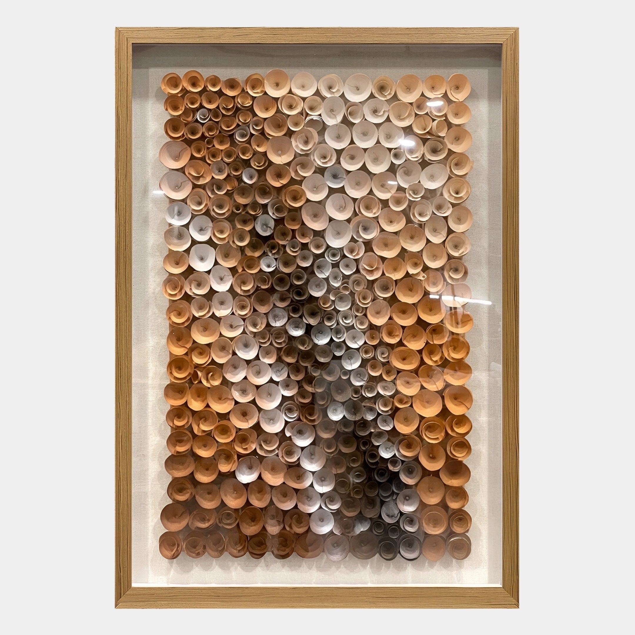 The Volaris Terracotta & Grey Rolled Floral Framed 3D Wall Art by Giant Sculptures displays rows of rolled paper cones in brown, beige, and cream tones, creating a stunning textured gradient effect for your wall.