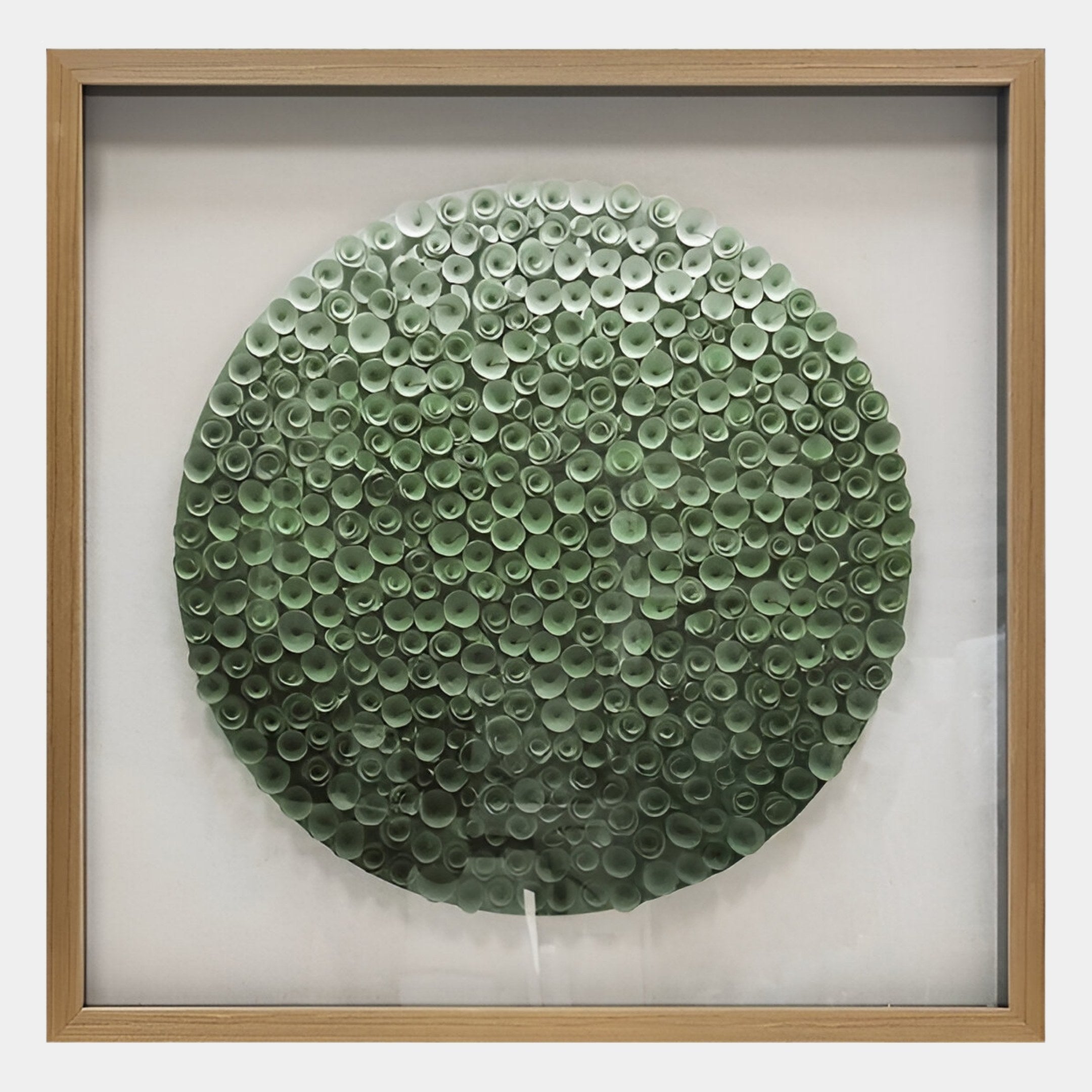 The Aureliare Forest Green Rolled Floral Framed 3D Wall Art by Giant Sculptures features small green paper tubes arranged in a circular, textured pattern resembling foliage, all set against a white background.