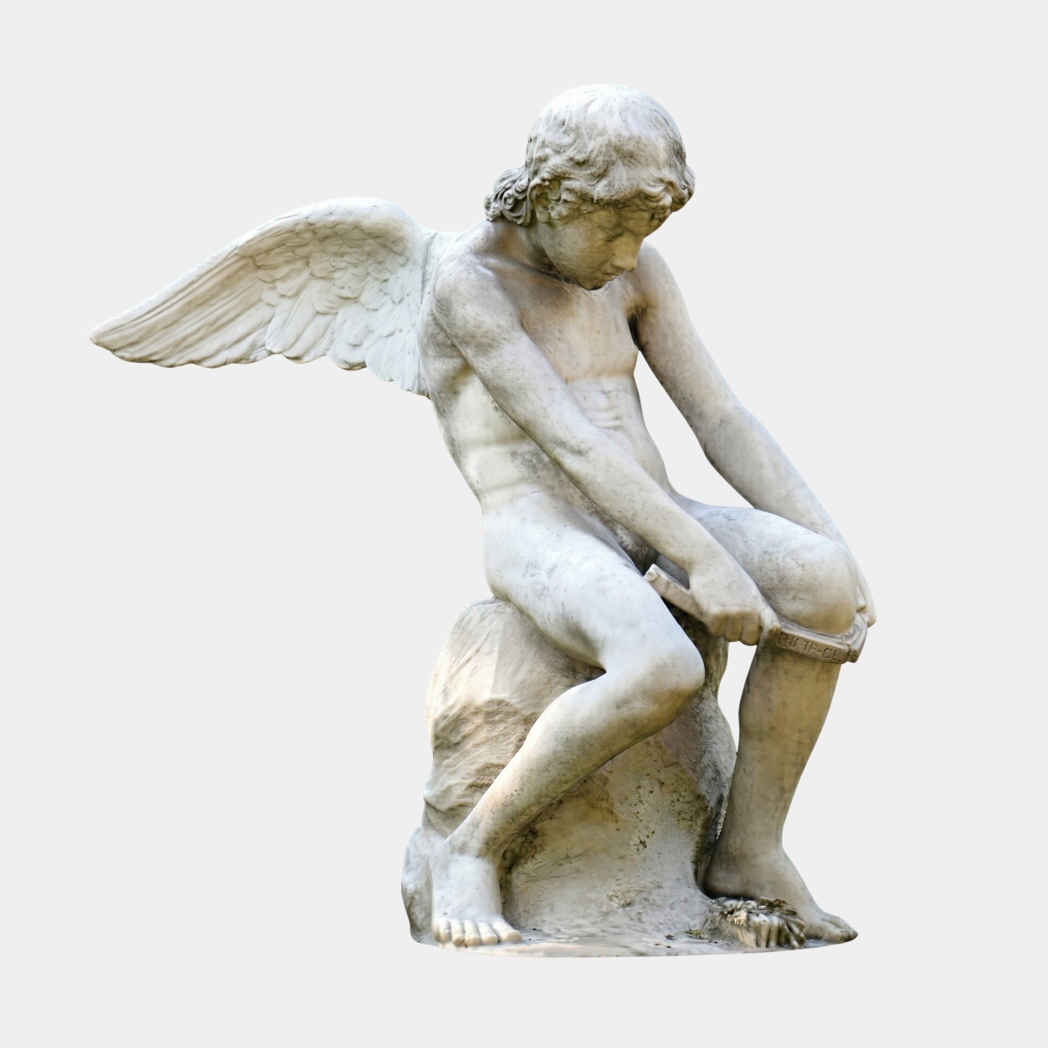 Winged Garden Boy Angel Marble Outdoor Sculpture in white natural marble, depicting a youthful angel seated on a rock with outstretched wings, shown against a light grey background.