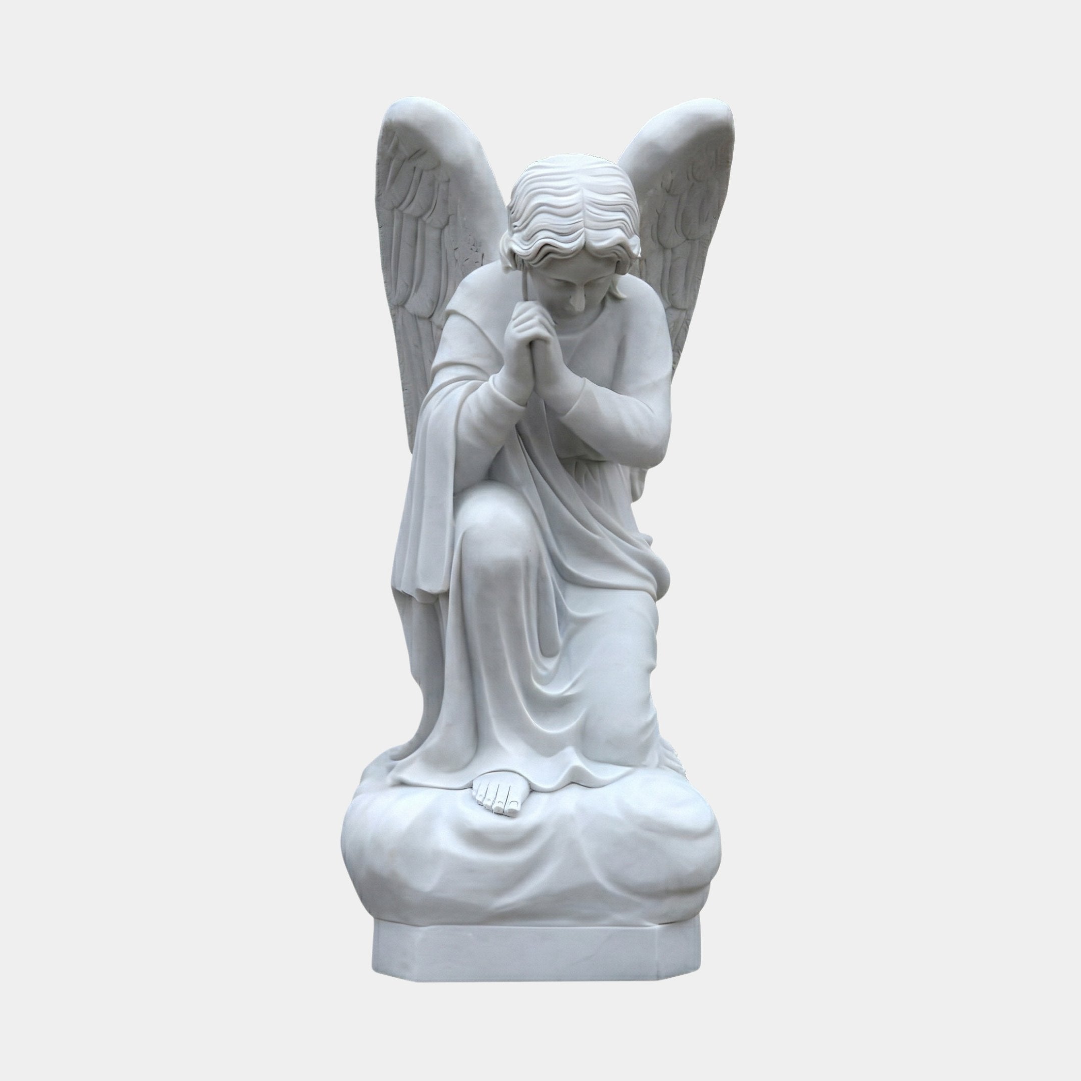 Sitting Angel Marble Outdoor Sculpture in white marble depicting a kneeling winged angel in flowing robes with hands clasped in prayer and head bowed, on a rounded base against a plain light background.