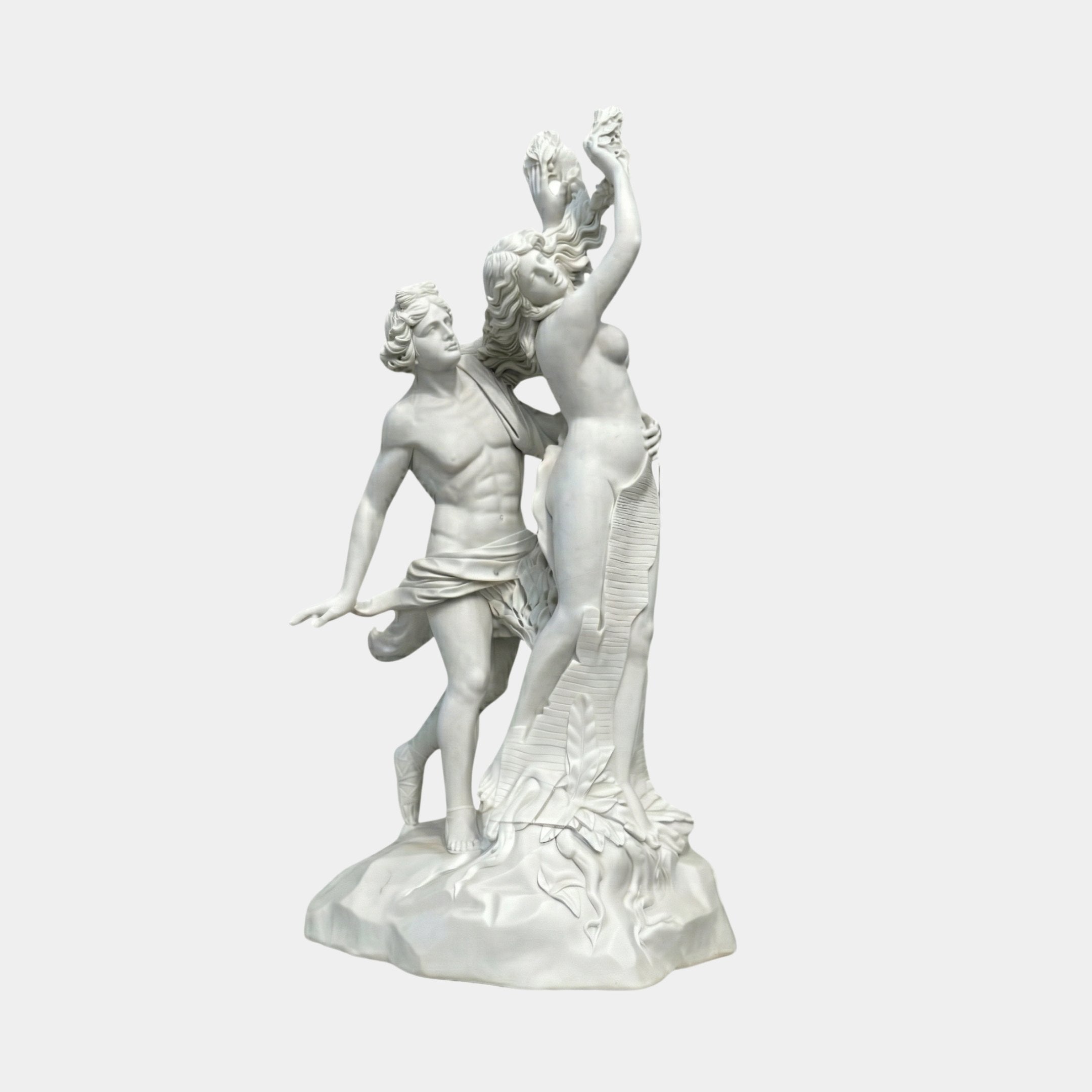 Apollo And Daphne Angel Marble Outdoor Sculpture by Giant Sculptures, 210cm white marble depiction of Daphne transforming into a laurel tree as Apollo reaches for her, on a rocky base, plain white background.