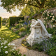 Angel Headstone Angel Marble Outdoor Sculpture by Giant Sculptures, 120cm white marble angel draped over a pedestal headstone, set in a walled English garden with roses and perennials.
