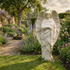 Standing Male Angel Marble Outdoor Sculpture by Giant Sculptures, 120cm tall in white marble with detailed wings and classical drapery, displayed in a lush English garden setting.