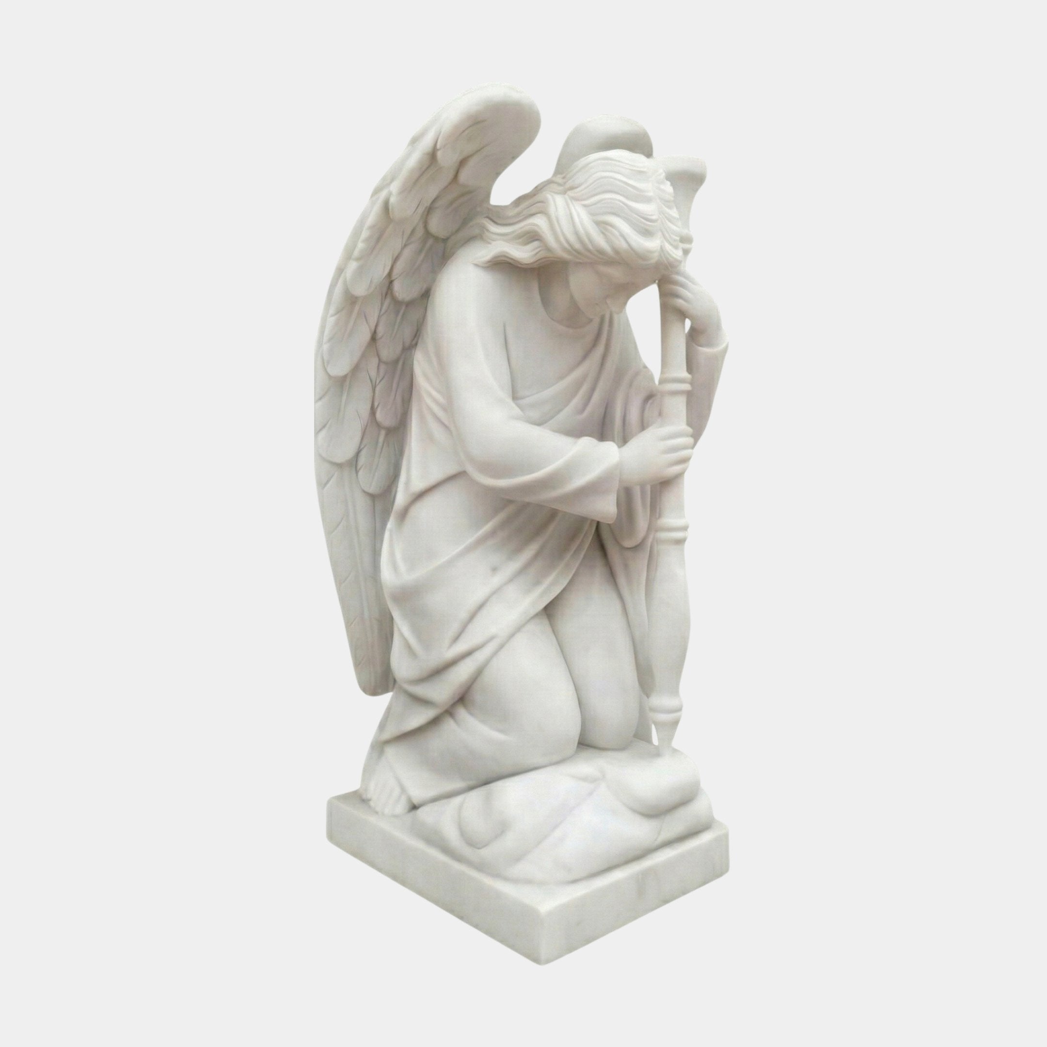 Winged Angel Marble Outdoor Sculpture by Giant Sculptures, depicting a kneeling angel in flowing robes holding a cross, carved in natural white marble on a square base, shown against a plain light background.