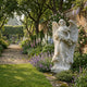 Giant Sculptures Flower Angel Marble Outdoor Sculpture – 180cm white marble winged angel holding a floral wreath, set in a walled English garden with foxgloves, lavender, and climbing roses.