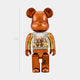 The Metallic Orange Beads Bear Sculpture by Giant Sculptures stands 70cm tall, featuring a shiny bronze and gold finish with a transparent torso filled with vibrant orange beads—an eye-catching contemporary art piece.