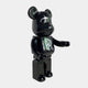 The Midnight Crest Bear Sculpture - 70cm by Giant Sculptures is a glossy black bear figure with a large RR logo on its chest and minimalist features, crafted from piano-gloss resin and posed with one arm raised.
