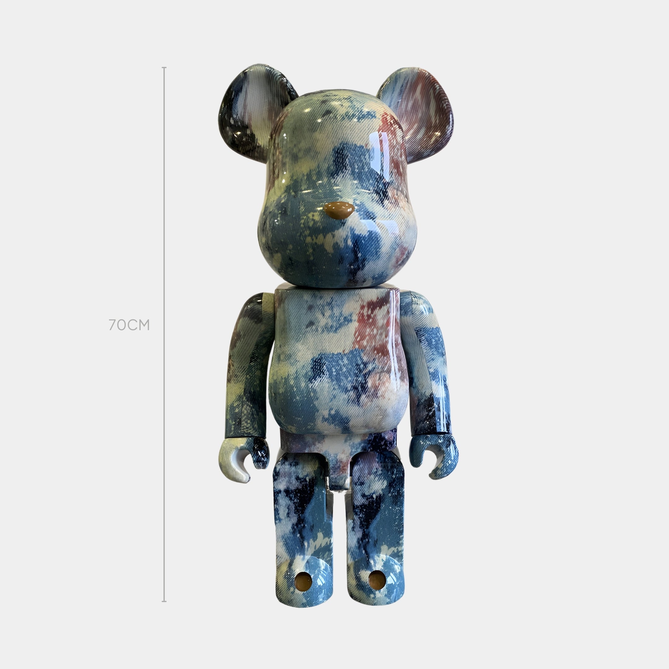 The Mistbound Tie-Dye Bear Sculpture by Giant Sculptures stands 70cm tall with a glossy blue, white, and red marbled finish, crafted from hydro-dipped resin and shown upright against a plain white background.