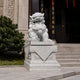 White marble guardian lion with an embroidered ball at a temple entrance