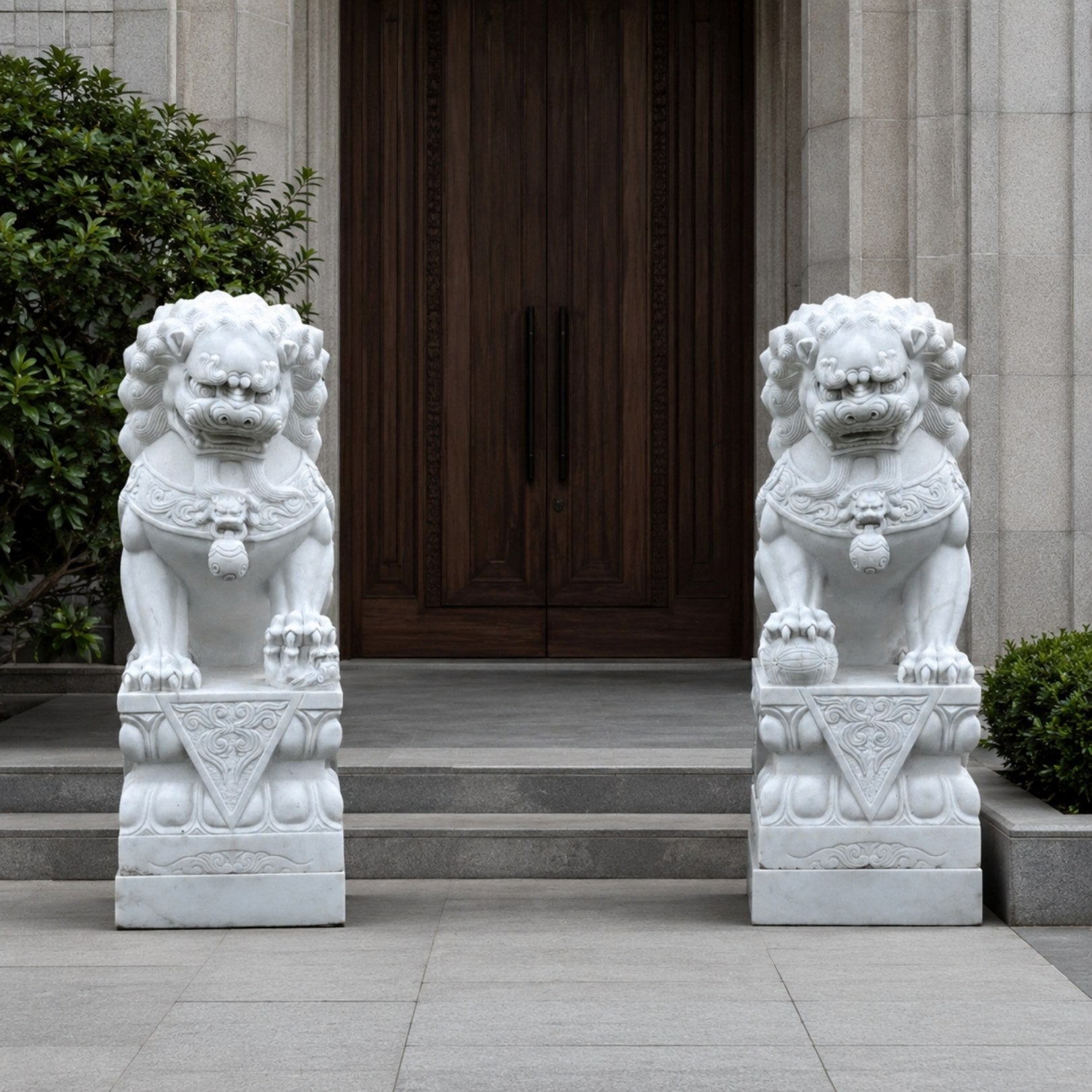The pair of white marble guardian lions flanking a doorway on their plinths