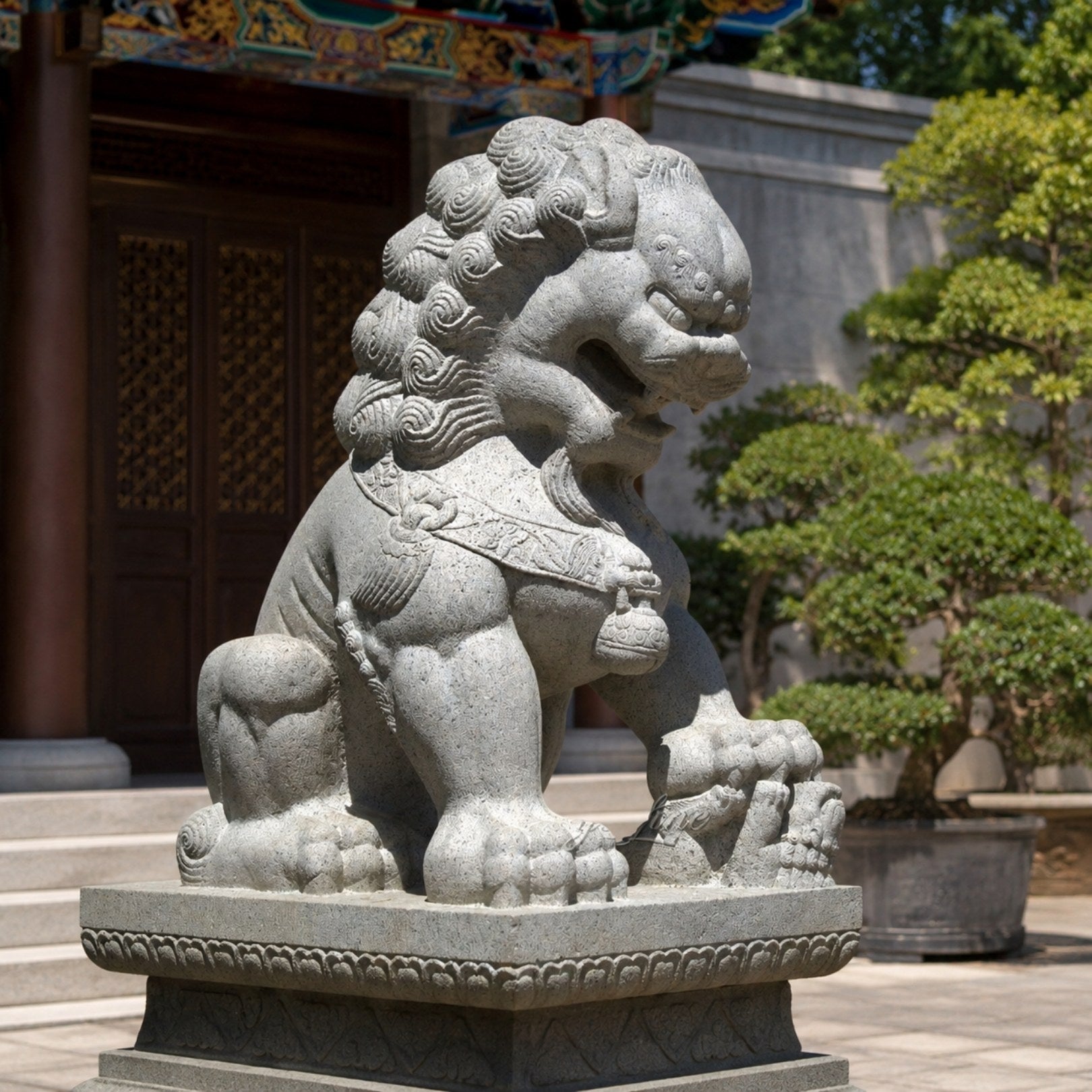 Grey granite guardian lion seated in a temple courtyard under a painted eave