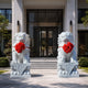 The pair of white marble guardian lions flanking the steps of a house entrance