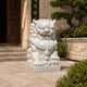 White marble guardian lion with its cub, on paving at a temple entrance