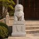 Cream marble guardian lion on its plinth beside a temple stair balustrade