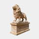Beige veined marble lion standing and roaring on a tall panelled plinth, 190cm